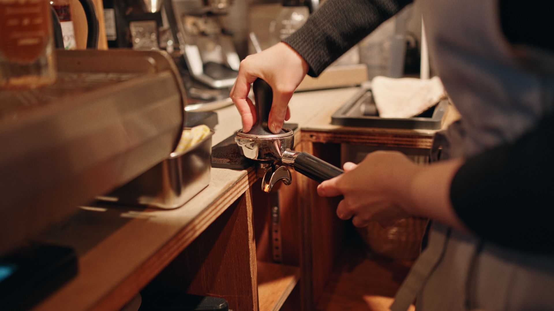 Barista tamping fresh grounds into a portafilter