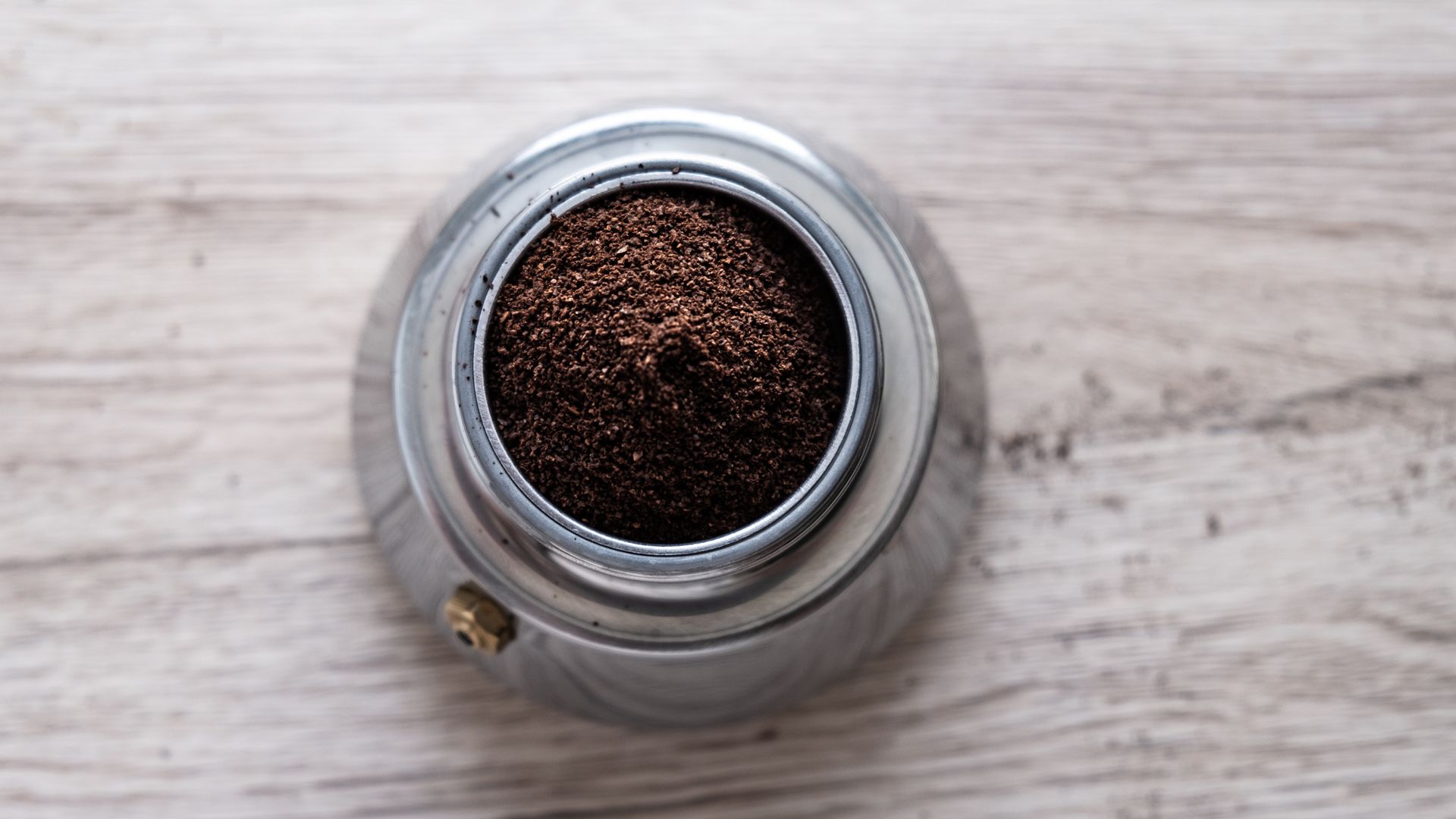 Freshly ground coffee in a moka pot, photographed from above
