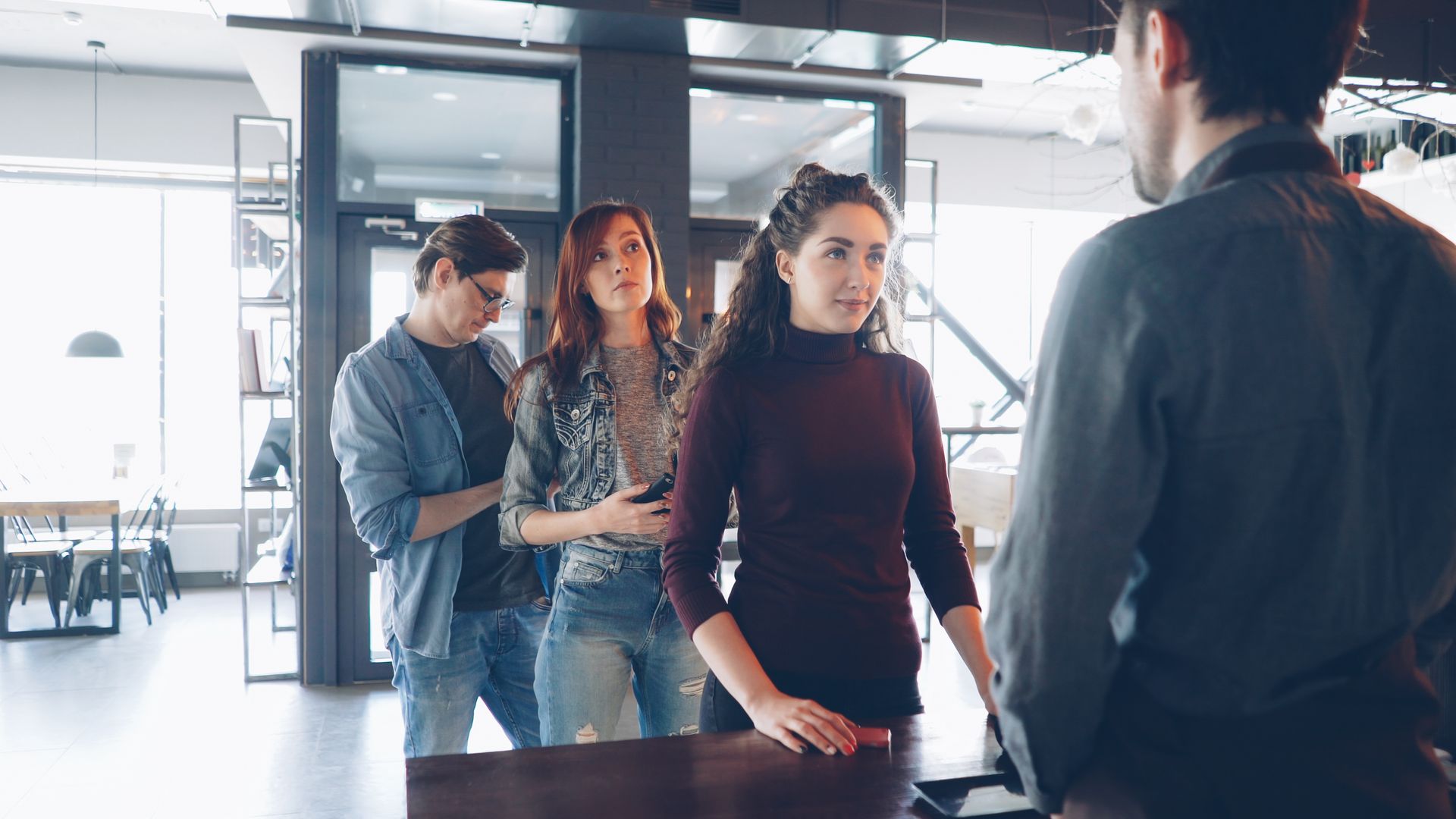 Customers queuing at a busy coffee shop counter